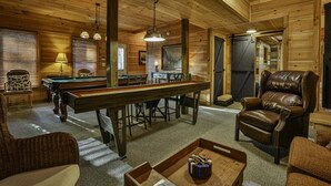 A cozy indoor setting with a pool table, leather chairs, and a billiards rack. - Riverview Hideaway by Mountain Oasis | Dog-Friendly Riverview Cabin in Coosawattee (Ellijay)