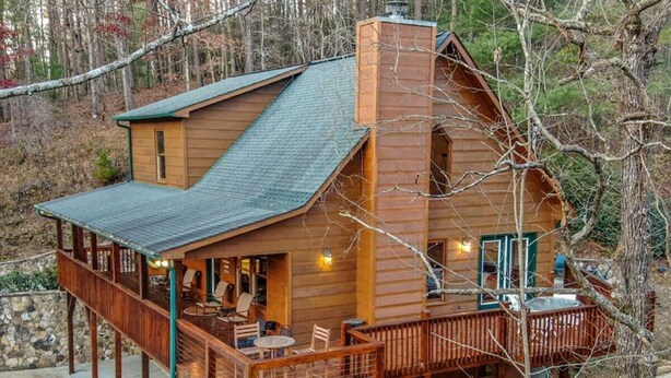 A wooden cabin with a deck, outdoor seating, and a fireplace. - Riverview Hideaway by Mountain Oasis | Dog-Friendly Riverview Cabin in Coosawattee (Ellijay)
