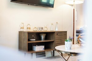A wooden console table with glass bottles, a metal bucket, and a calendar marked '26 JULY'. - Spacious 4 BR/2 BA – 4 Min Walk to DT Ferndale! (Ferndale)
