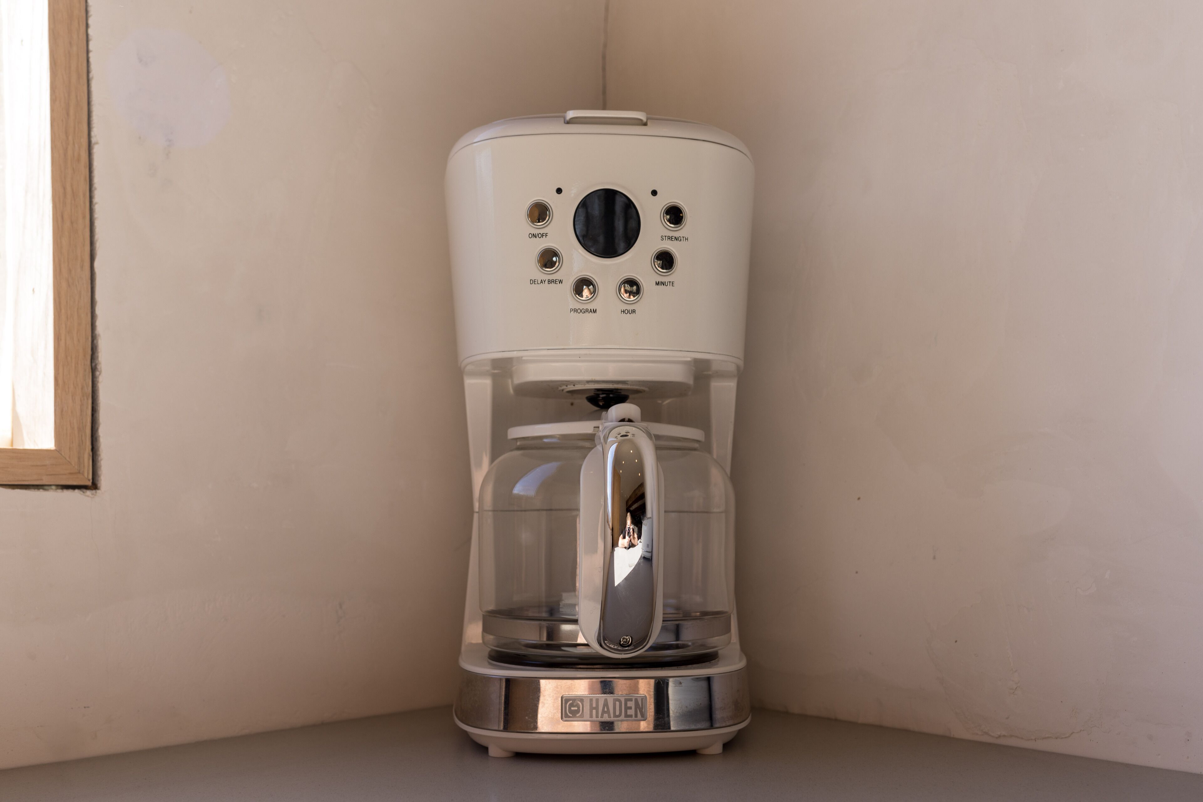 A coffee maker with a control panel, brand name, and a glass carafe.