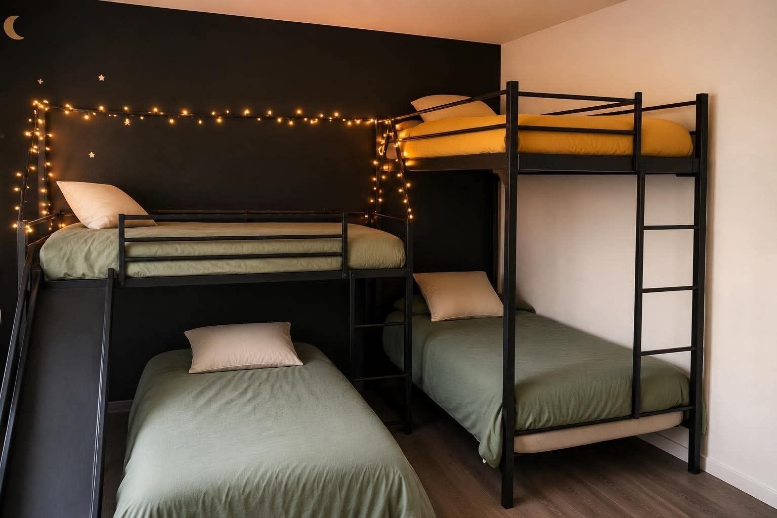 Une chambre avec un lit superposé, une échelle, un mur décoré de guirlandes lumineuses et un croissant de lune en guise de décoration.
