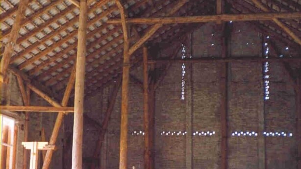 An indoor venue with a high wooden ceiling and a long table set for a meal. - Renovated farmhouse in the northern Uckermark, between lakes and forests (Brüssow)