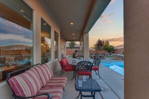 An outdoor patio with a pool, seating area, and dining setup. - Sand Hollow 3370 | Private Pool, Hot Tub, Ping Pong, and near Sand Hollow Reservoir (Hurricane)