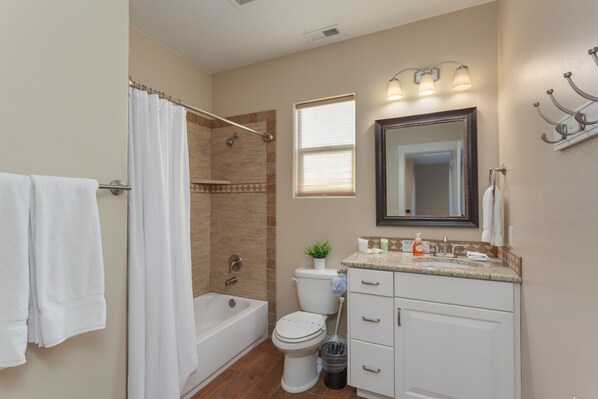 A bathroom with a bathtub, toilet, and sink.