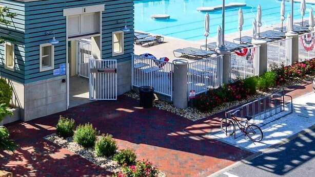 Un espace piscine agrémenté d’un kiosque, de chaises longues et offrant une vue sur l’océan.
