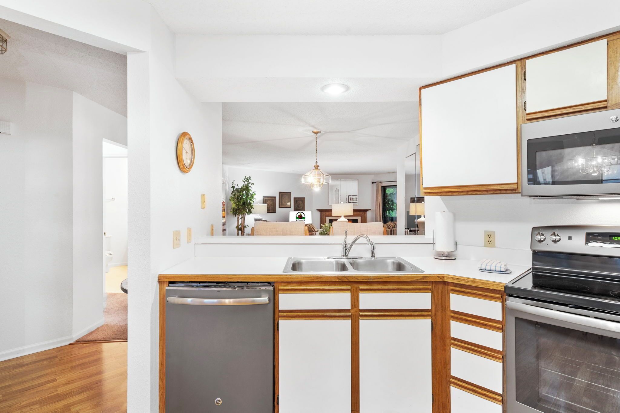 Eine moderne Küche mit Spülmaschine, doppelter Spüle und eingebautem Backofen.