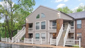 A multi-story building with a brick facade, multiple windows, and two staircases leading to the entrance. - 2 Bed, 2 Bath with Screened Lake View Patio! (Branson)