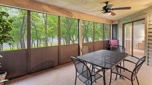 A room with a large window, a ceiling fan, and a table with chairs. - 2 Bed, 2 Bath with Screened Lake View Patio! (Branson)