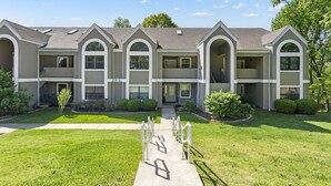 A multi-story residential building with a symmetrical facade, large windows, and a central entrance. - 4BR, 3BA Golf Condo Ticket Deals and Resort Amenities (Branson)