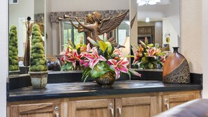 A bathroom vanity with a mirror, a decorative angel statue, and various potted plants. - 4BR, 3BA Golf Condo Ticket Deals and Resort Amenities (Branson)