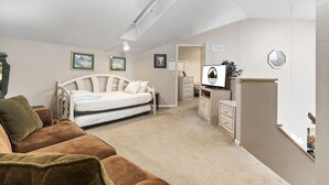 Een slaapkamer met een bed, een televisie, een bureau en een stoel.