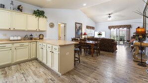 A spacious kitchen with a large island, wooden flooring, and cream-colored cabinetry. - Family Escape w/ Balcony Views | Near 76 Strip | Branson Attractions (Branson)