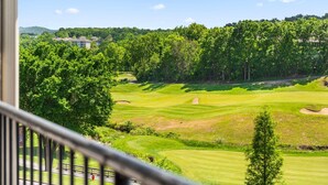 Blick auf einen Golfplatz mit einem Gebäude im Hintergrund.