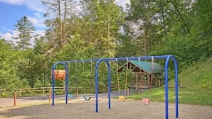 A playground with swings and a wooden structure in the background. - Next to Rocky Top Sports! 5 King bedrooms 4 Bath Family-Friendly Sleeps 18 (Gatlinburg)
