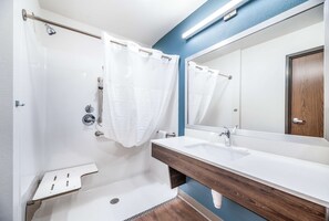 Een bad/douchecombinatie, een haardroger, handdoeken, zeep