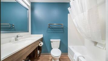 A bathroom with a white sink, a toilet, and a bathtub.
