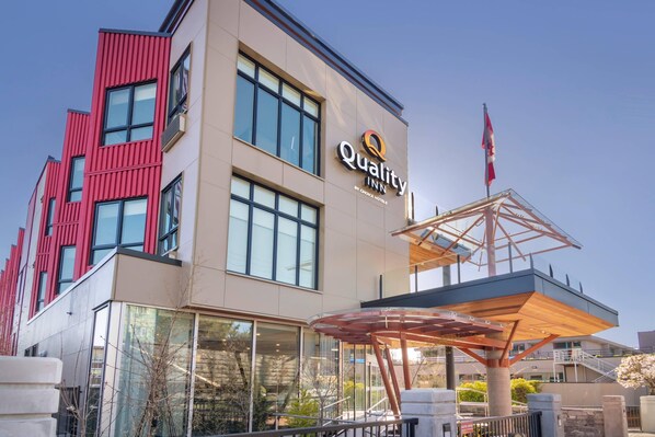 A hotel with a modern facade, large windows, and a prominent outdoor seating area. - Quality Inn (Nanaimo)