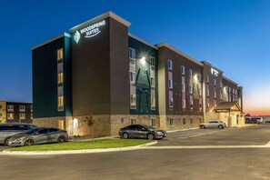 A hotel with a modern design, multiple floors, and a parking lot.