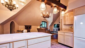 A spacious kitchen with a large island, wooden cabinets, and a chandelier. - 'The Castle Gatehouse' of Highlands Castle (Bolton)