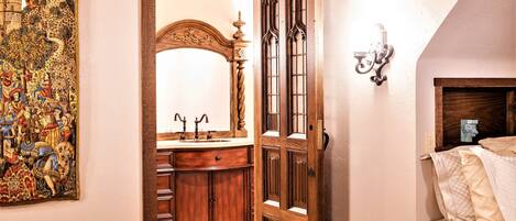 A bedroom with a wooden bed, a nightstand, a dresser, and a large mirror.