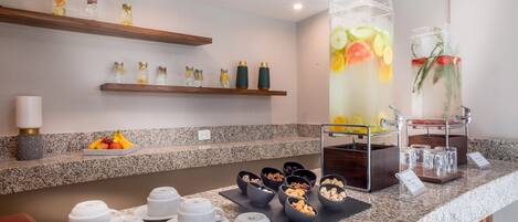 A breakfast buffet setup with various food items and beverages.