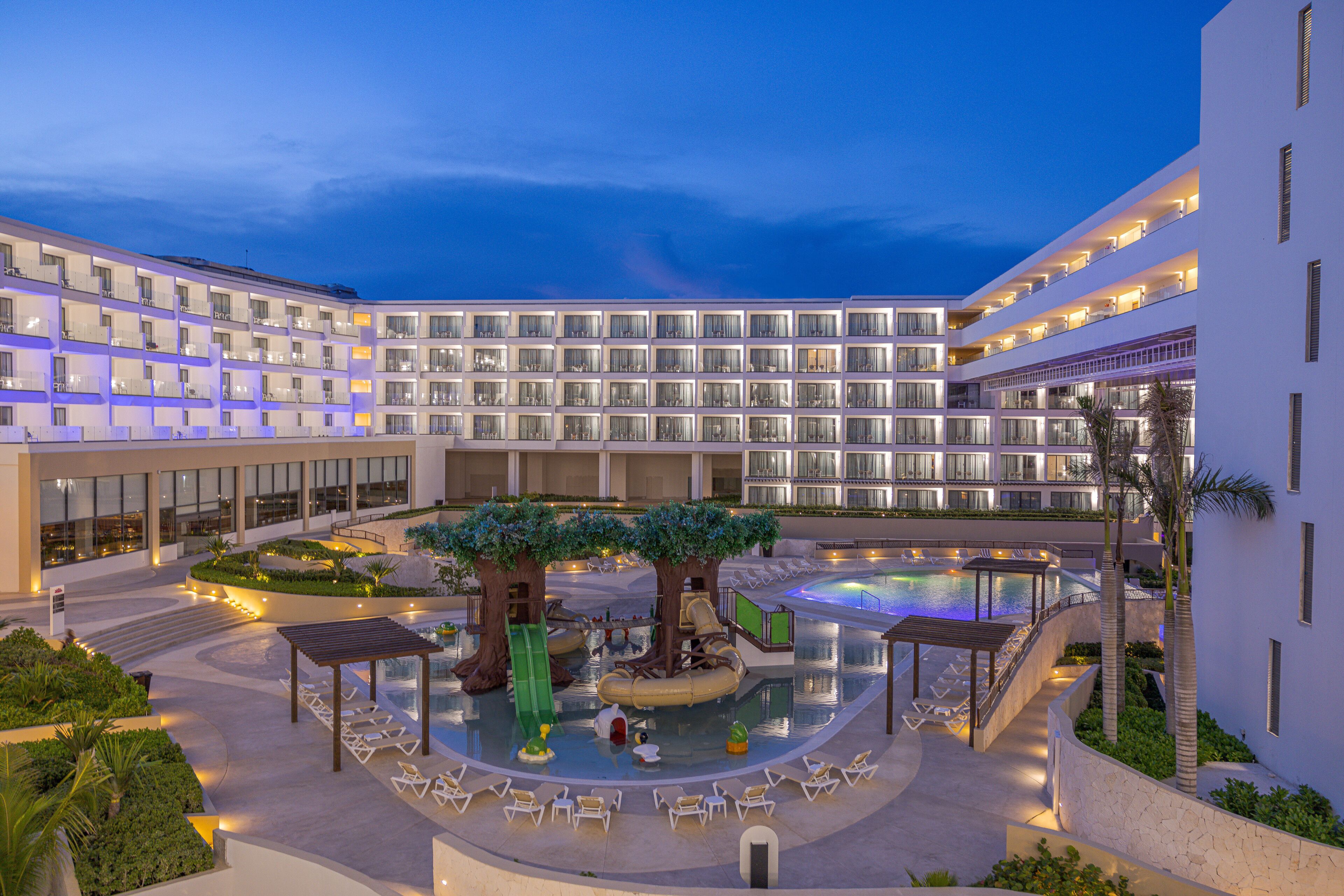 A hotel with multiple floors, a swimming pool, and a children's play area.
