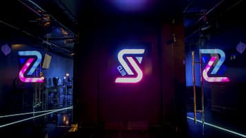 A hallway with a large illuminated 'Z' logo on the wall, indicating a club or similar venue.