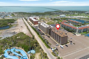 An aerial view of a hotel with multiple buildings, a parking lot, and a water park. - 1st Floor 1 Bedroom Condo near Beach  w/Pool!! (South Padre Island)