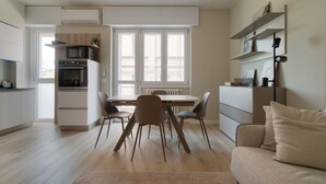 Una cocina moderna con comedor, sofá y radiador.