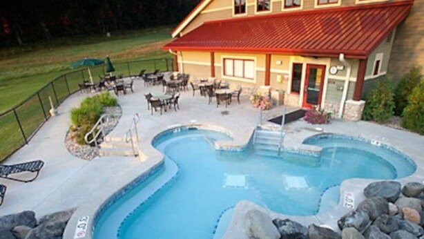 A swimming pool with a unique shape, surrounded by rocks and a patio area with outdoor furniture. - Dells Resort - Free Mini Golf + Kayaks + NO daily fee D (Dellona)