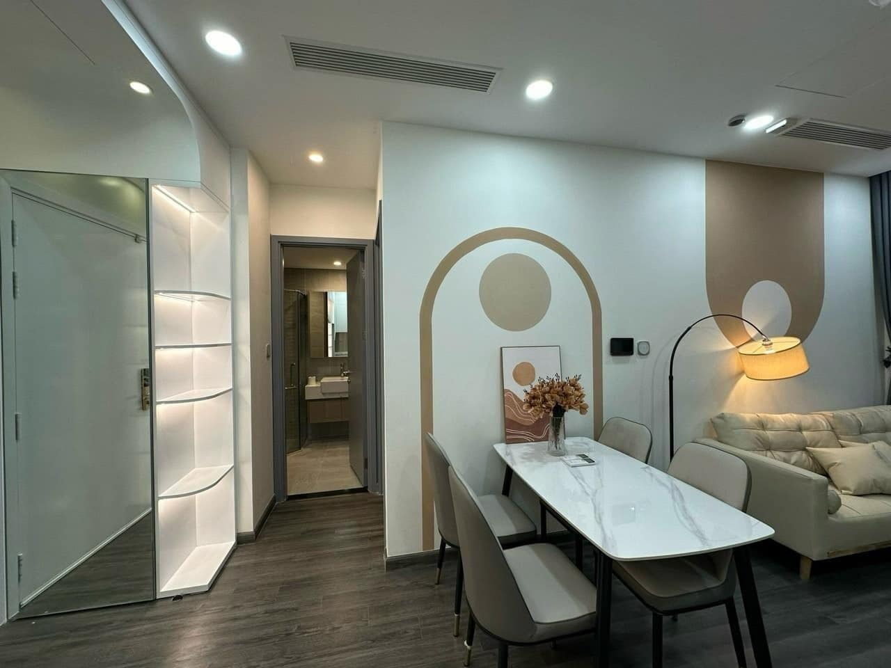 A modern hotel room with a dining area, a sofa, and a lamp.