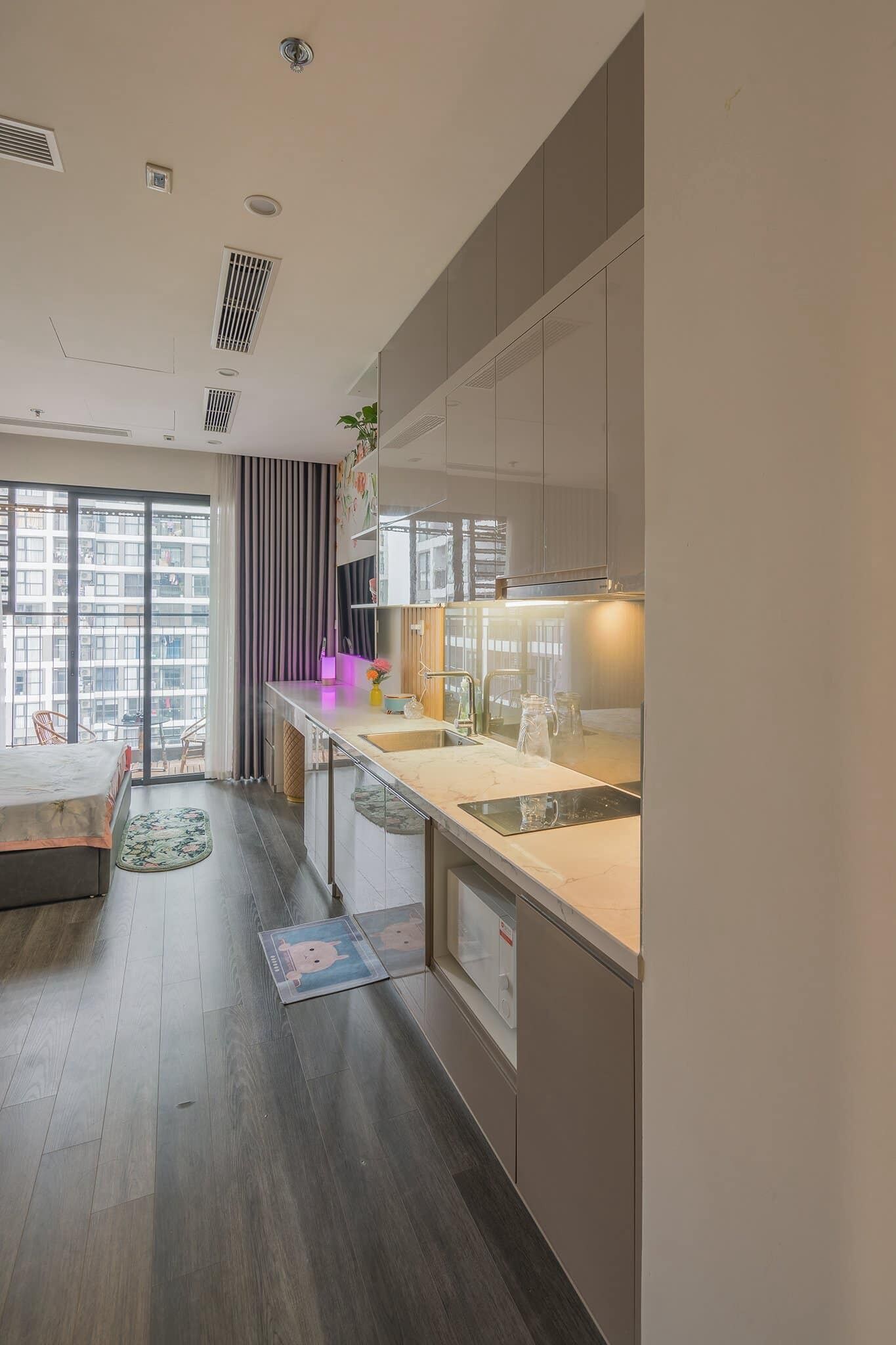 A modern kitchen with a large window, a dining area with a table and chairs, and a view of the cityscape.