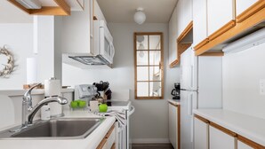 A modern kitchen with white cabinetry, stainless steel appliances, and a wooden countertop. - Outpost: Balsam Lodge A3 - Aspens Location! (Wilson)
