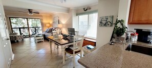 Relax in this open-plan living space with a dining table, sofa, and kitchen area.