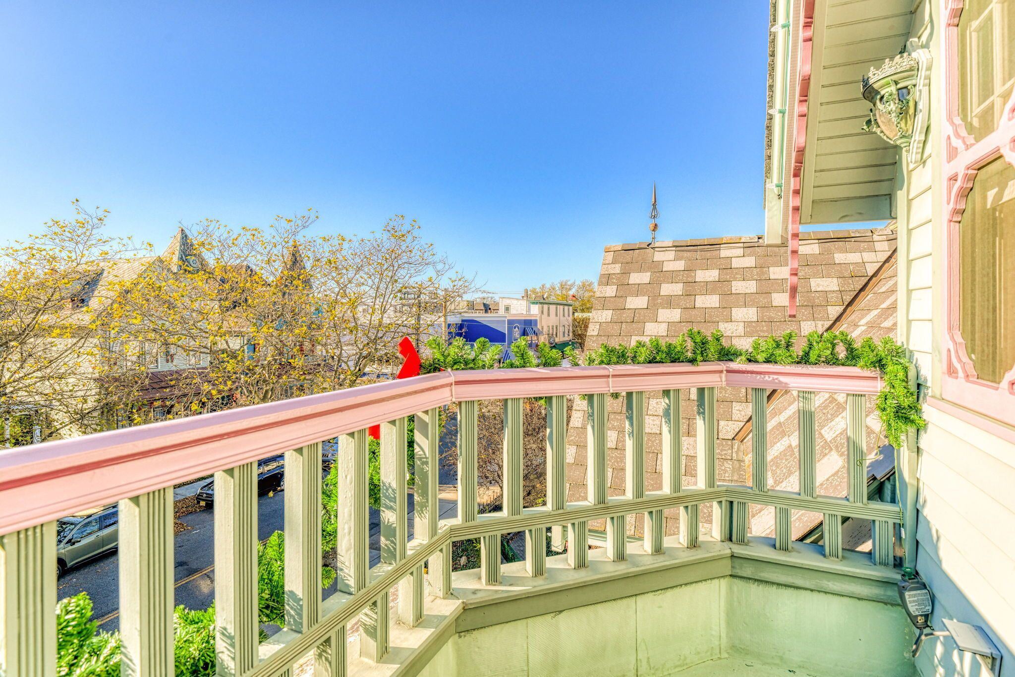 A staircase with a pink railing leading to a building with a brick facade.