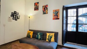 Un salon avec un canapé, une table basse et des œuvres d’art accrochées aux murs.