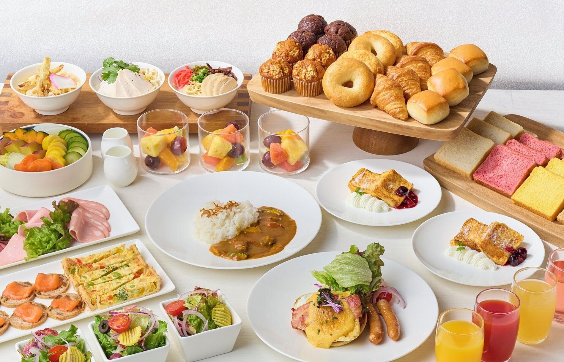 Una variedad de opciones de desayuno, como cruasanes, muffins y copas de fruta.