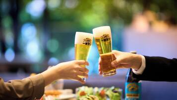 Dos personas brindando con vasos de cerveza en una mesa con una ensalada y una botella de cerveza.