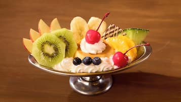 A dessert with various fruits and a cherry on top.