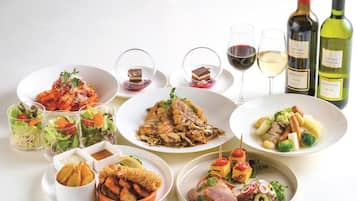 A variety of dishes and wine bottles on a table.