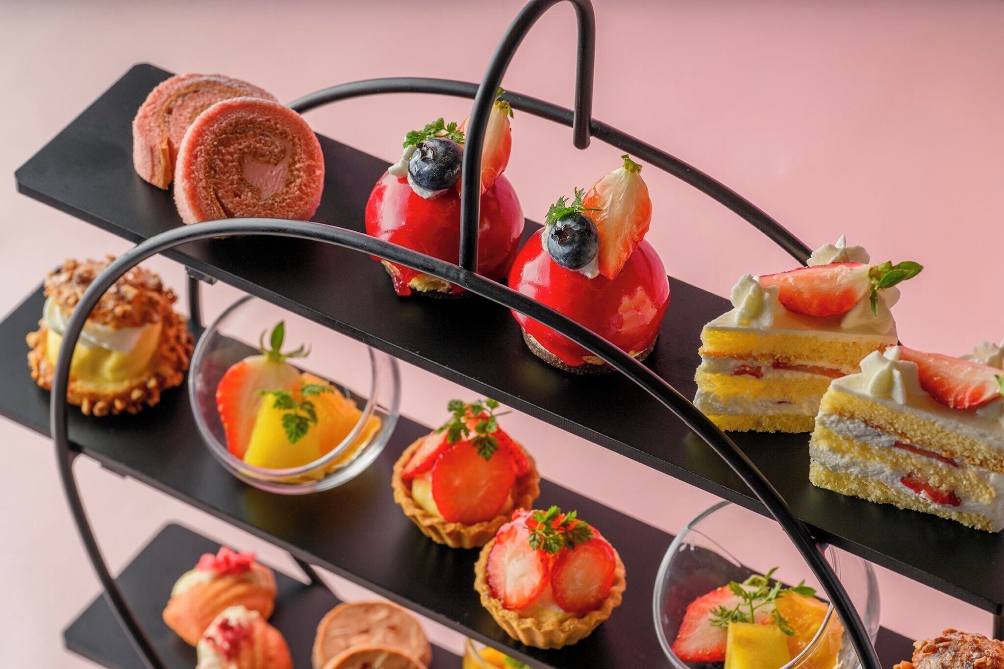 A multi-tiered dessert display with various types of pastries and desserts.