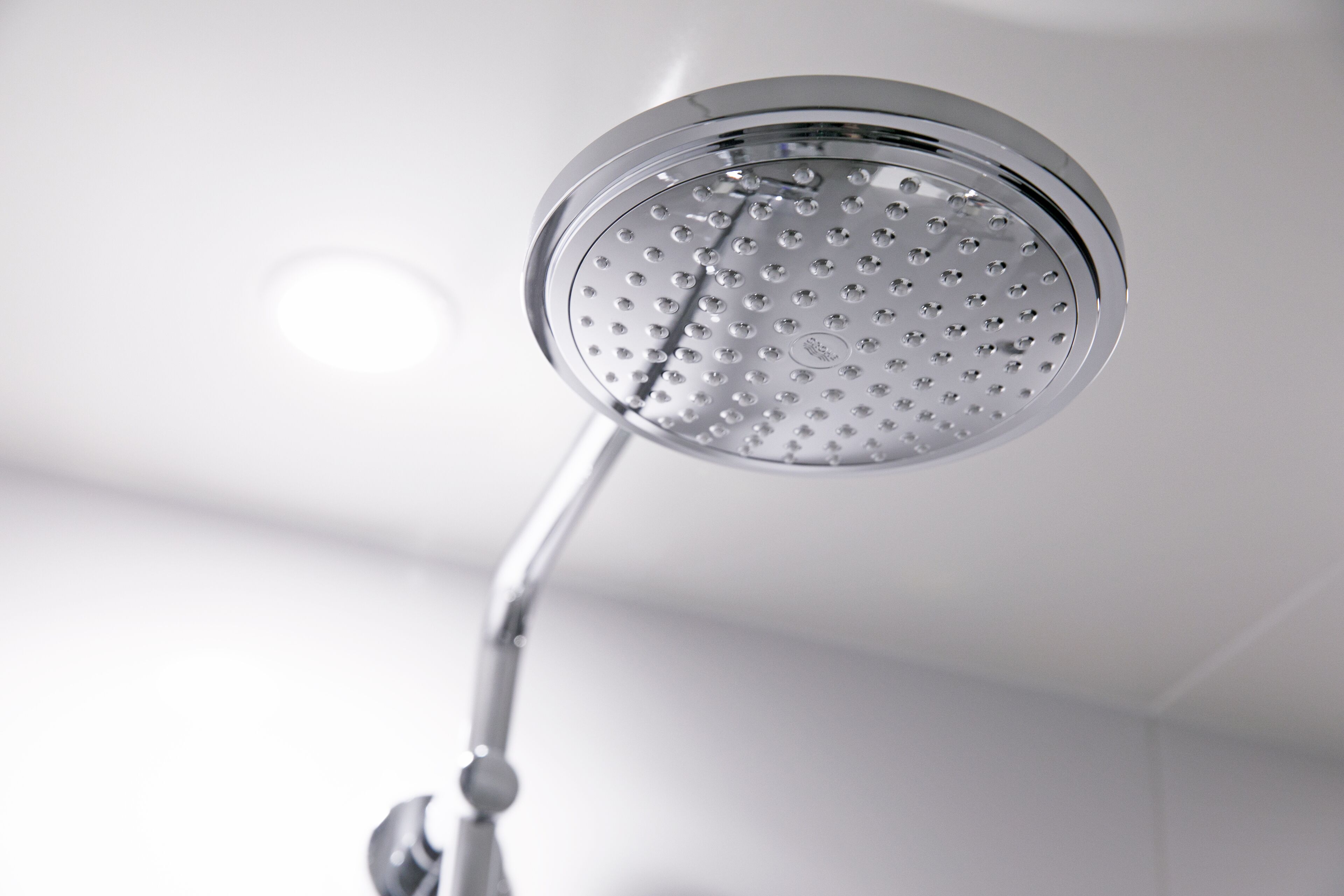 A modern showerhead with a circular design and multiple nozzles.