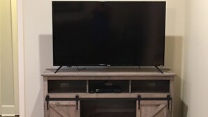 Un téléviseur à écran plat posé sur un meuble de télévision en bois, de style rustique.