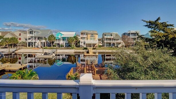 A waterfront property with multiple buildings, a dock, and a swimming pool.