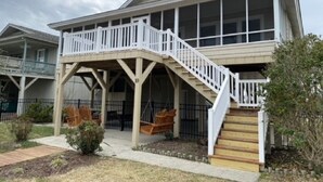 A two-story house with a covered porch and a staircase leading to the upper floor.