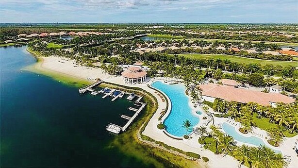 An aerial view of a resort with a large swimming pool, a marina, and lush greenery. - Luxury resort rental (Fort Myers)