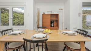 Een eethoek met een houten tafel, vier stoelen en een koffieapparaat op de achtergrond.