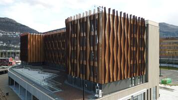 A modern building with a unique wooden facade and large windows.