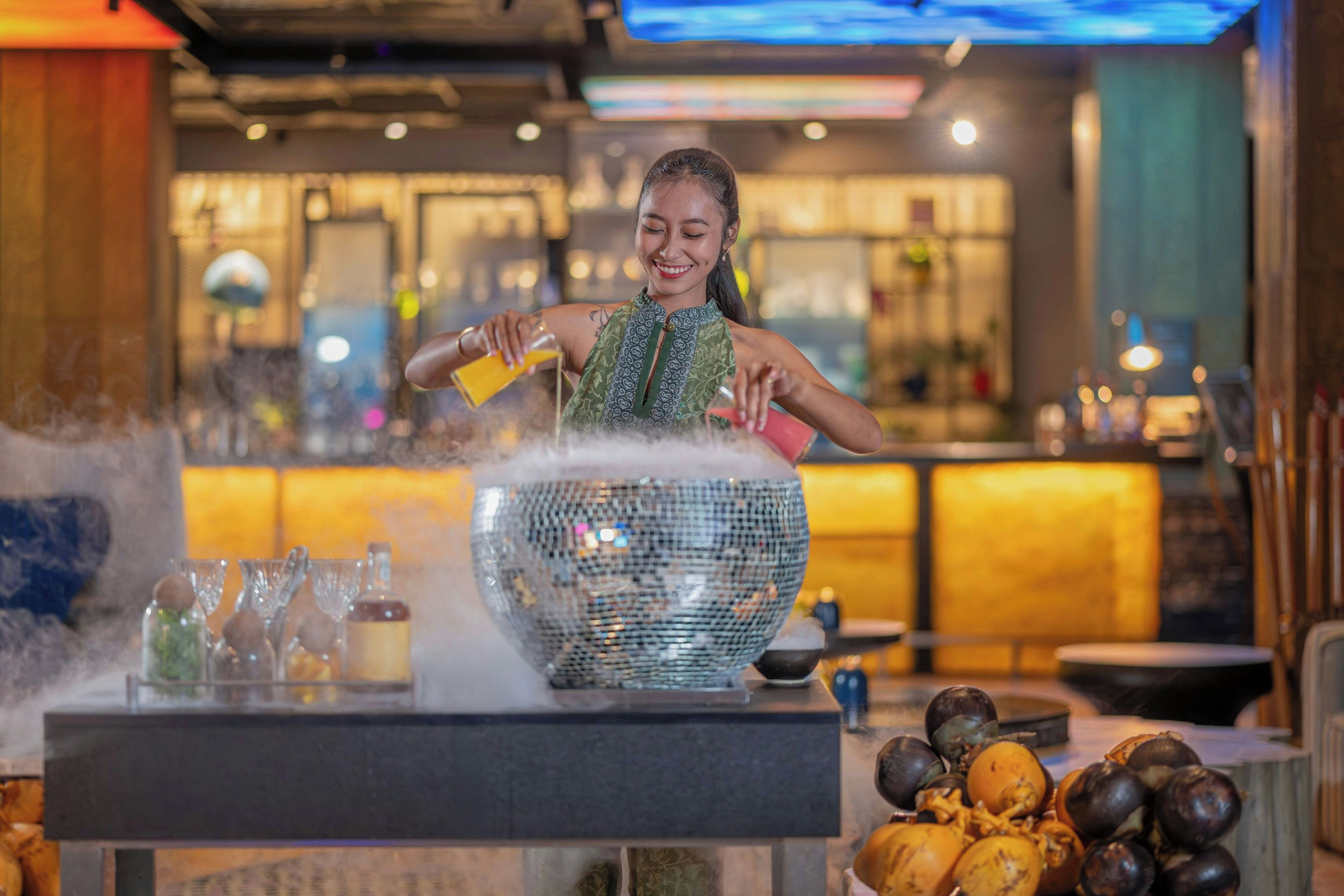 A bartender preparing a drink with a large, decorative bowl.