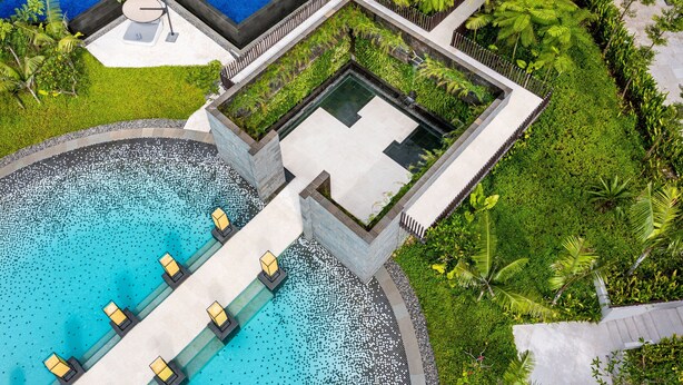 An aerial view of a resort with a large pool, a separate infinity pool, and lush greenery. - Renaissance Bali Nusa Dua Resort (Nusa Dua)